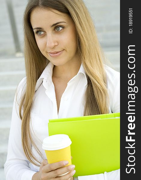 Business woman with a green folder and paper cup of coffee. Business woman with a green folder and paper cup of coffee