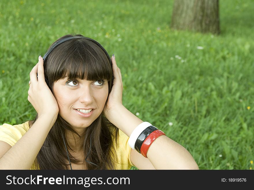 Smiling young woman listening to music at park