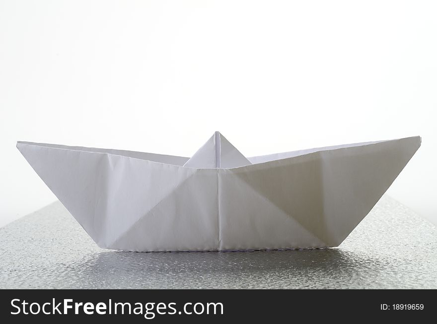 Ship of paper on a metal plane