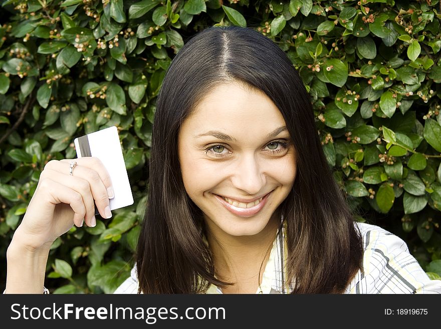 Young beautiful woman outdoors with a plastic credit card. Young beautiful woman outdoors with a plastic credit card