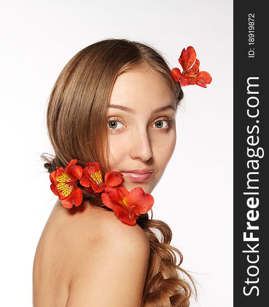 Portrait of the beauty young blond girl with lily in her hair