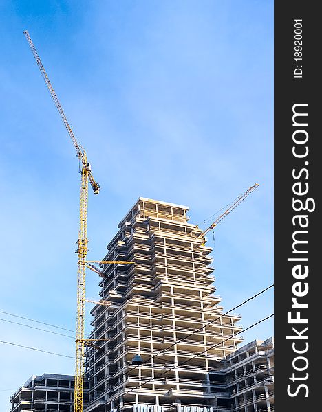 Bright yellow lift cranes on the site of high-rise building. Bright yellow lift cranes on the site of high-rise building