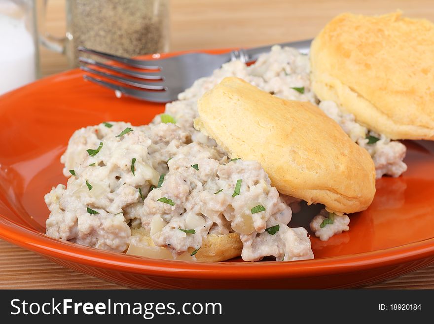 Sausage gravy on top of biscuits on a plate. Sausage gravy on top of biscuits on a plate