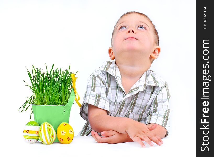 Easter egg hunt. Cute little boy with Easter eggs and basket the green spring grass Isolated on white background
