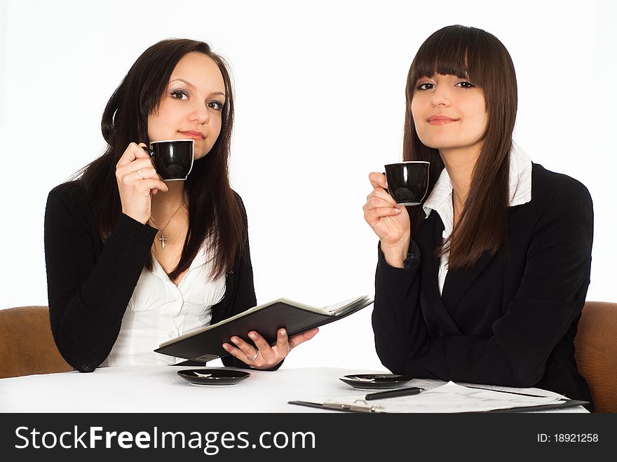 Two beautiful business women sitting at the table