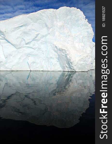Iceberg perfectly reflected in the dark ocean. Iceberg perfectly reflected in the dark ocean