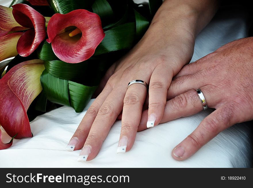 Hands with wedding rings and wedding bouquet
