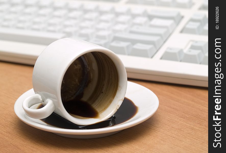 Coffee mug with inverted on a wooden table against the background keyboard