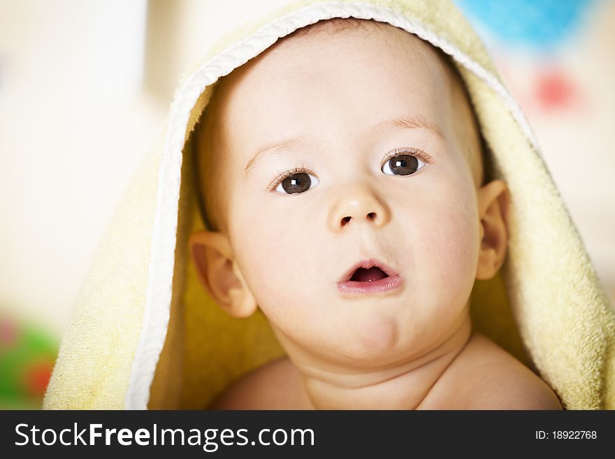 Close up portrait of sweet naked baby boy with yellow towel on head looking innocently with colorful background. Close up portrait of sweet naked baby boy with yellow towel on head looking innocently with colorful background.