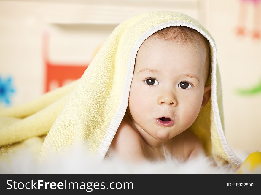 Portrait of sweet naked baby boy with yellow towel on head looking innocently with colorful background. Portrait of sweet naked baby boy with yellow towel on head looking innocently with colorful background.
