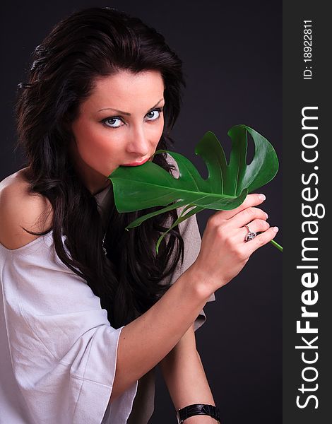 Beautiful brunette fooling around with a green leaf