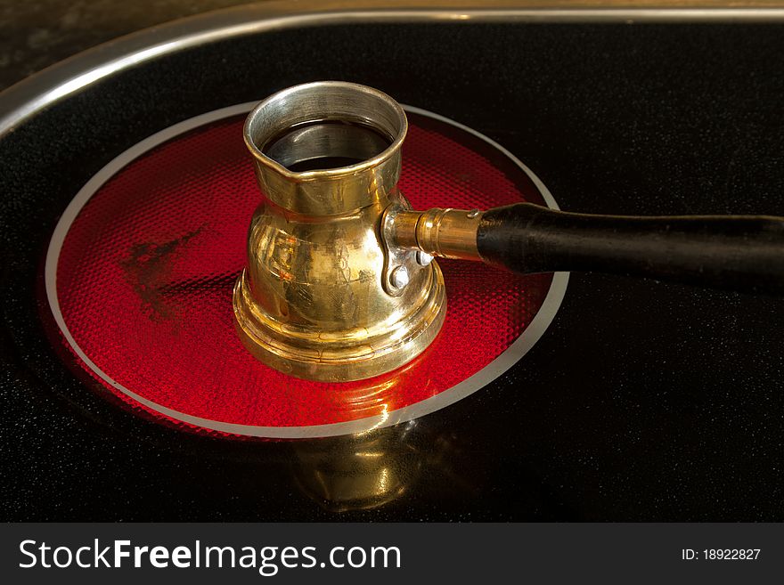 Arab small coffee pot on red hot ceramic stove of electric cooker. Arab small coffee pot on red hot ceramic stove of electric cooker