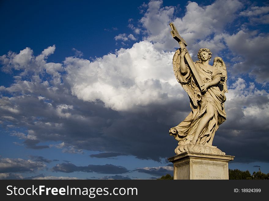 Picture of a statue of an angel with cloudy sky on background