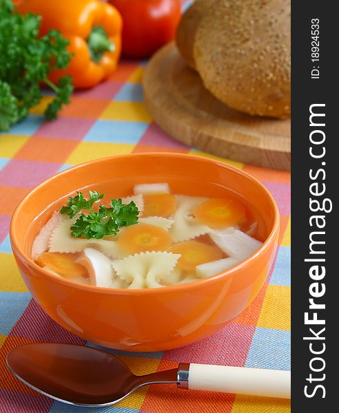 Hot homemade chicken soup with farfalie in the orange bowl. Hot homemade chicken soup with farfalie in the orange bowl.