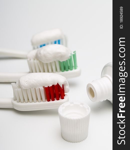 Colorful toothbrushes with toothpaste and a tube