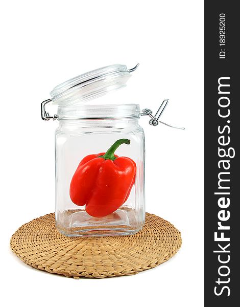 Red pepper in glass jar on white background