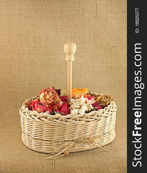 Dry flowers in the basket on jute background