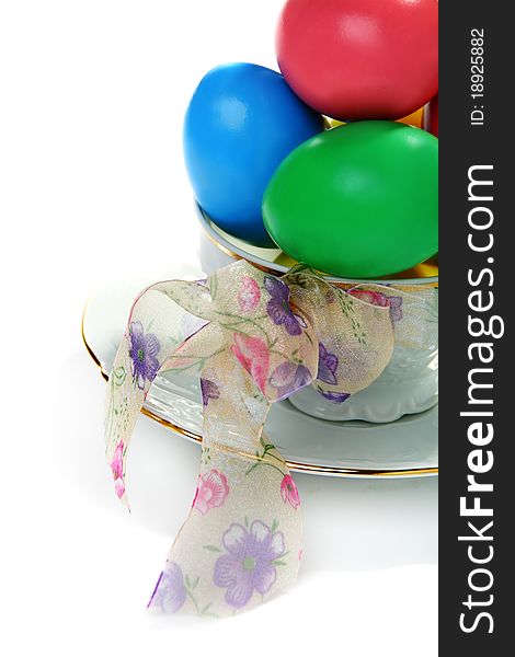 Easter eggs in a teacup on a white background.