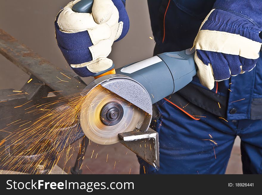 A man working with grinder, close up on tool, hands and sparks, real situation picture. A man working with grinder, close up on tool, hands and sparks, real situation picture