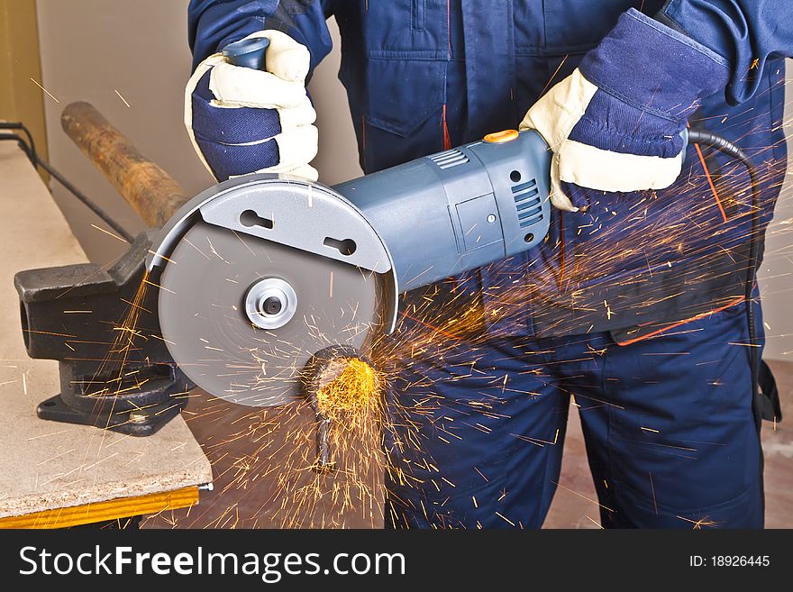 A man working with grinder, close up on tool, hands and sparks, real situation picture. A man working with grinder, close up on tool, hands and sparks, real situation picture