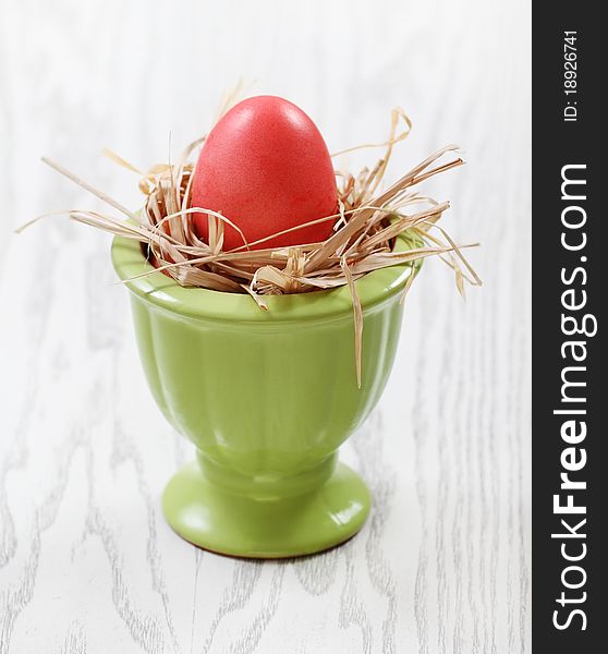 One egg in vase on wooden background