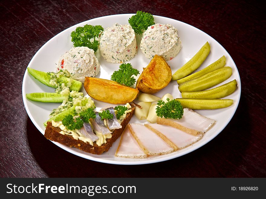Appetizing cold dish, cucumbers, fat, garlic, a potato, a sandwich with a herring, a cheese cream