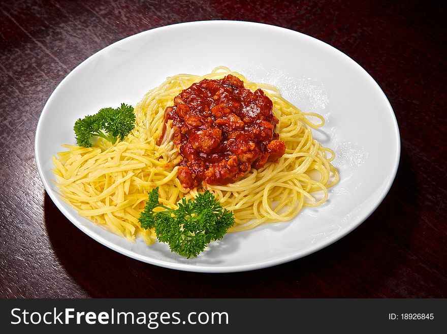 Appetizing spaghettis with tomato sauce, meat, cheese and greens