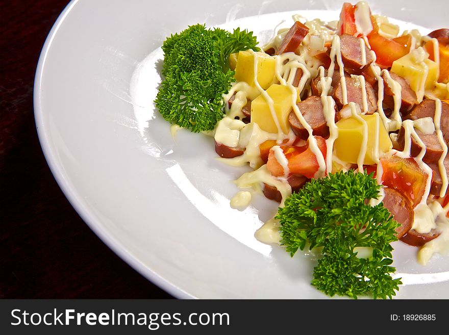 Appetizing salad from the Bavarian sausages, cheese, tomatoes and greens