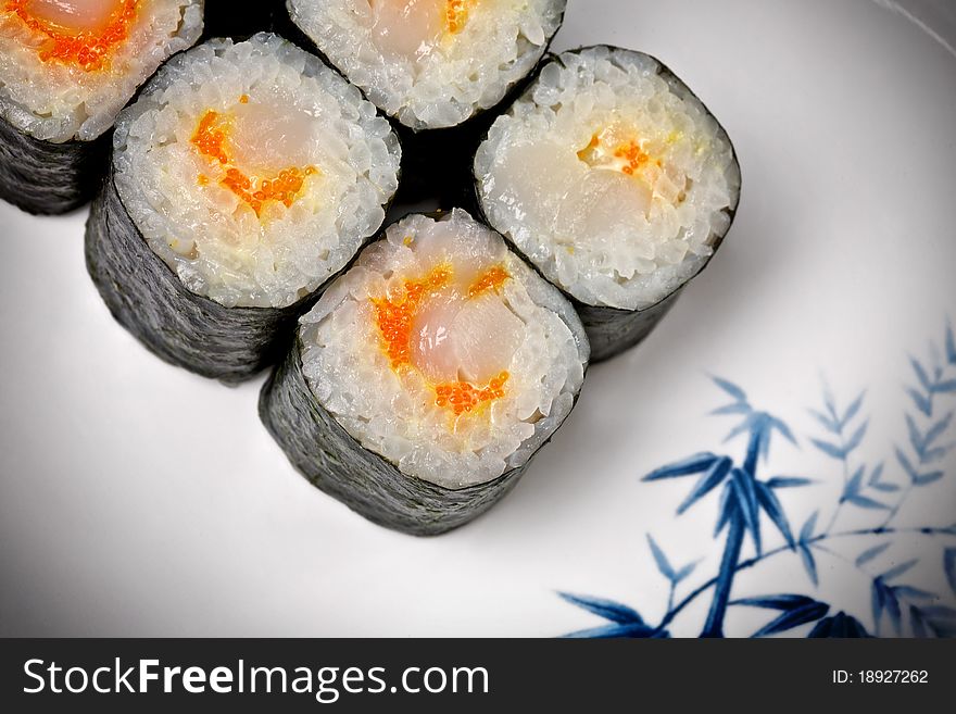 Sushi - Roll made of Smoked Eel, Cream Cheese and Deep Fried Vegetables inside. Fresh Salmon outside. Sushi on the plate