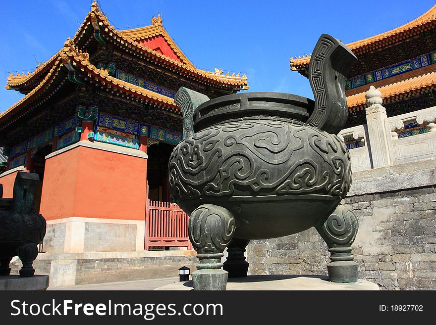 A incense burner in front of temple.