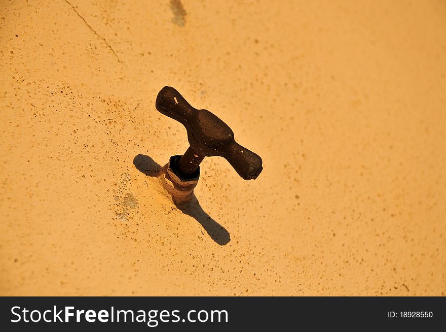 Rusty water tap on the wall