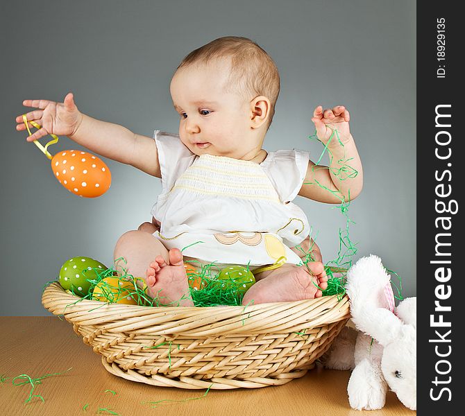 Young babay girl sitting and playing with easter egg. Very cute baby. Young babay girl sitting and playing with easter egg. Very cute baby.