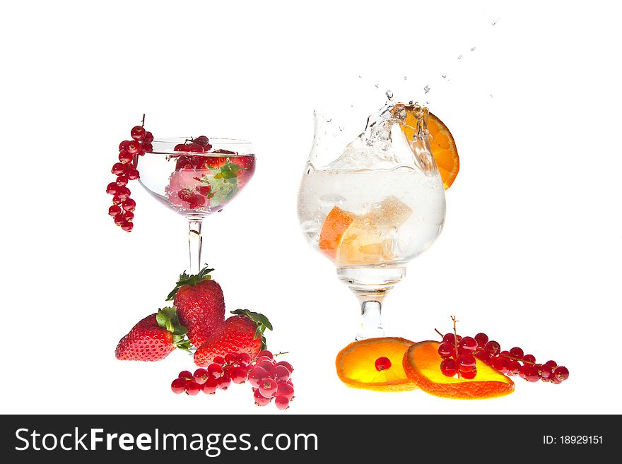 Fresh fruits dropped in glass of sparkling water