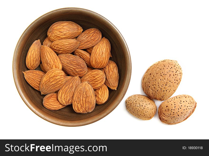 Fresh almonds in the clay bowl isolated on white