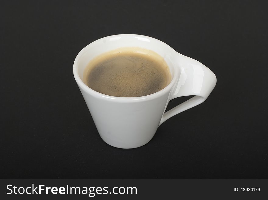 White cup of coffee without plate on black background