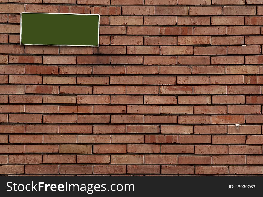 Brick wall with green sign on it. Brick wall with green sign on it
