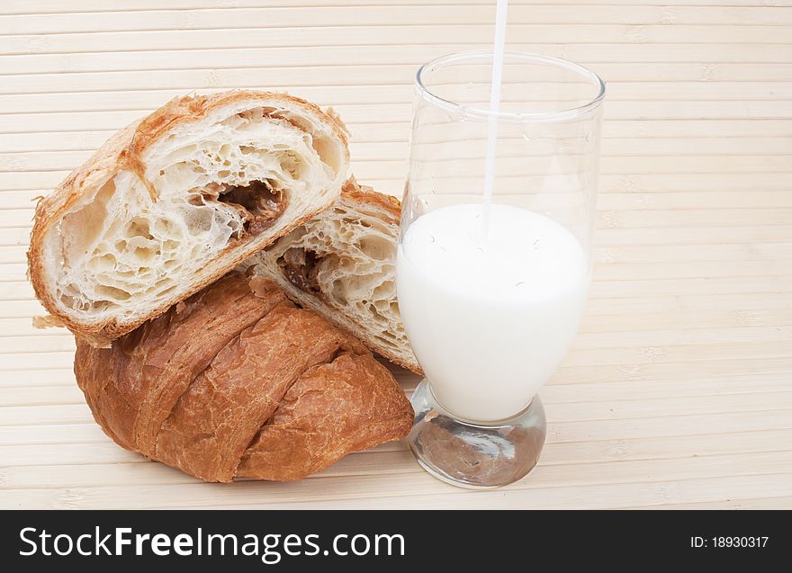 Croissants with milk on a wooden background