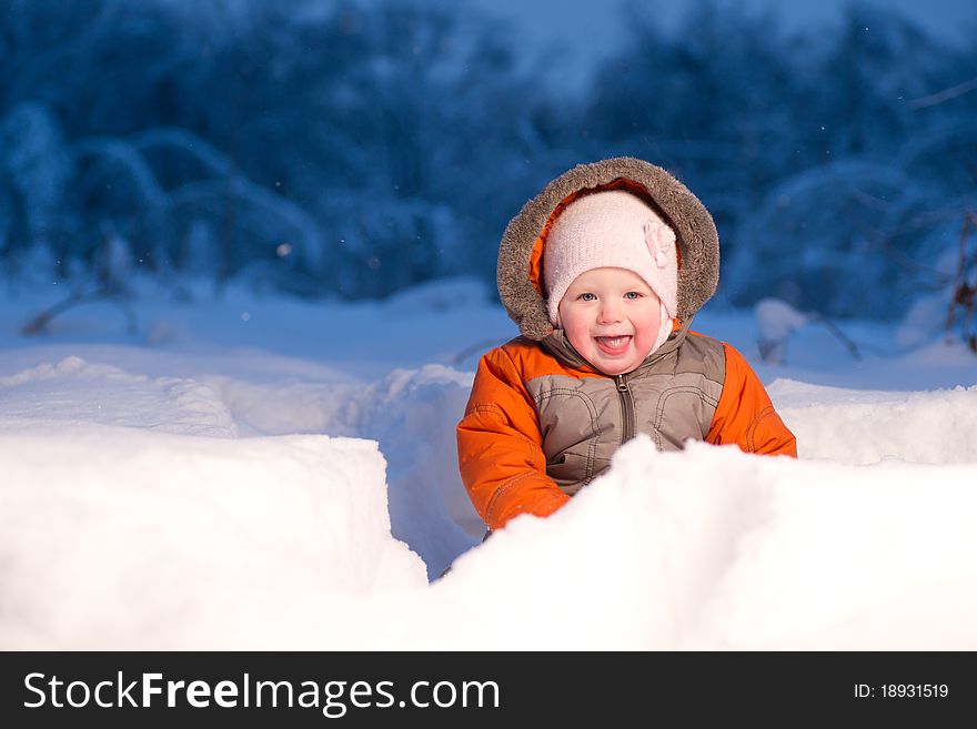 Adorable baby sit and digging hideout in snow