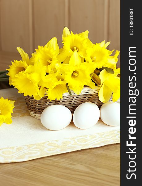 Flowers narcissus and eggs ona wooden surface