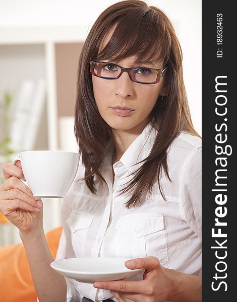 Coffee break - businesswoman with cup sitting on the couch