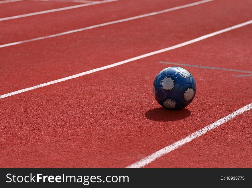 Dark blue soccer ball on run race track