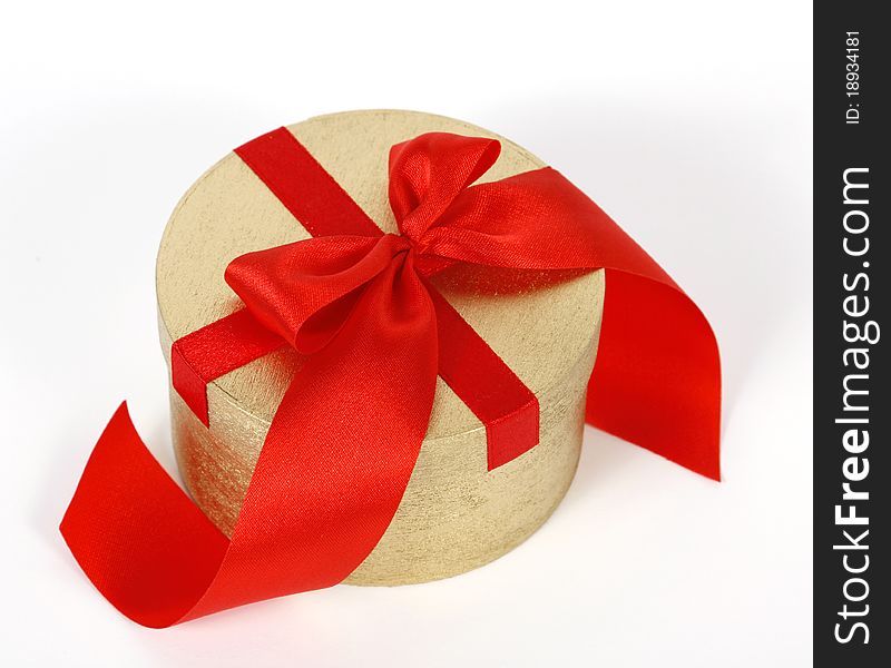 Golden box decorated with the red ribbon. Golden box decorated with the red ribbon