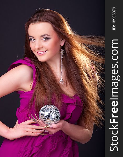 Beautiful long-haired brunette in a dress of fuchsia and a disco ball. Beautiful long-haired brunette in a dress of fuchsia and a disco ball