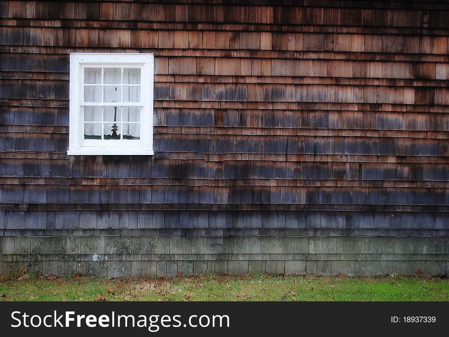 Image of a white color window on a brown wall. Image of a white color window on a brown wall