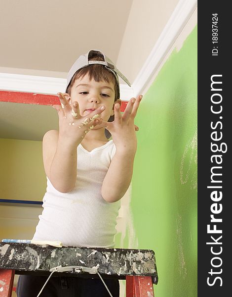 Young boy on a ladder with paint on his hands. Young boy on a ladder with paint on his hands.