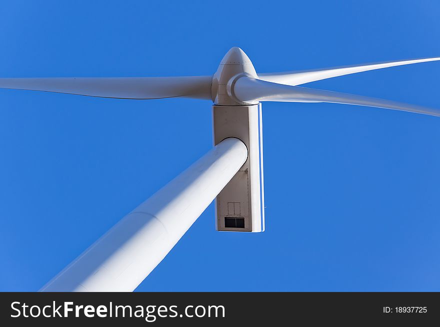 An image of wind turbine against blue sky