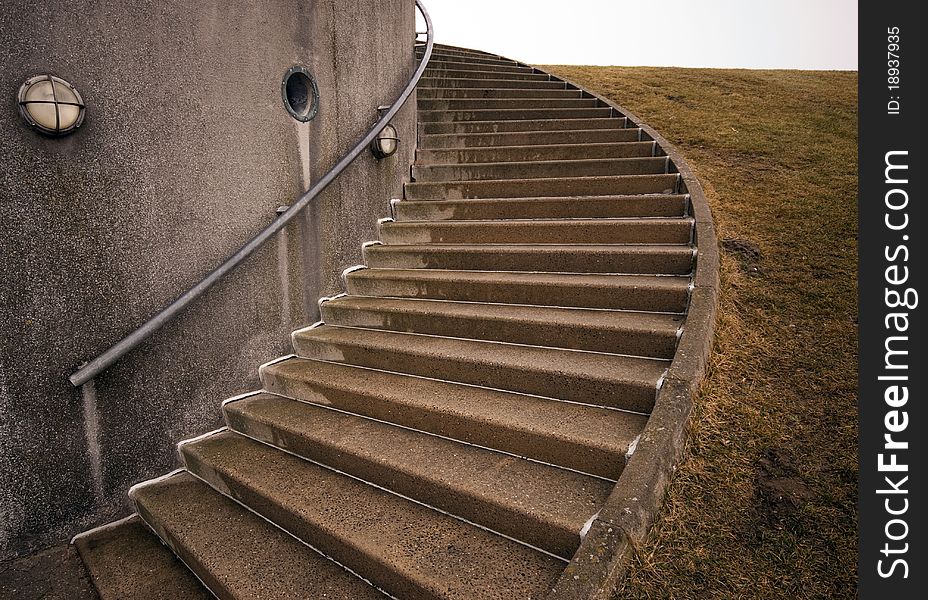 Spiraling stairs outdoors close to building and dike, Denmark. Spiraling stairs outdoors close to building and dike, Denmark.