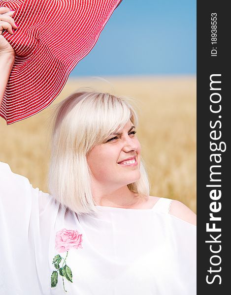 Beautiful woman with hat in wheat meadow on sunny day