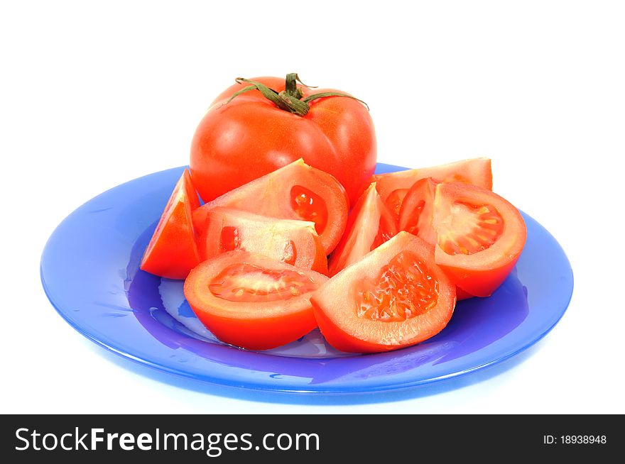 Tomato on a blue plate, isolated on a white background. Tomato on a blue plate, isolated on a white background