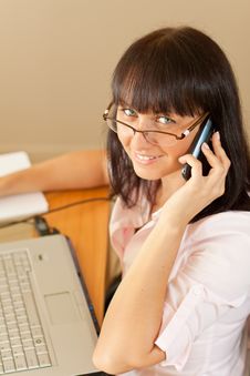Young Female Talks Over Mobile In The Office Royalty Free Stock Image